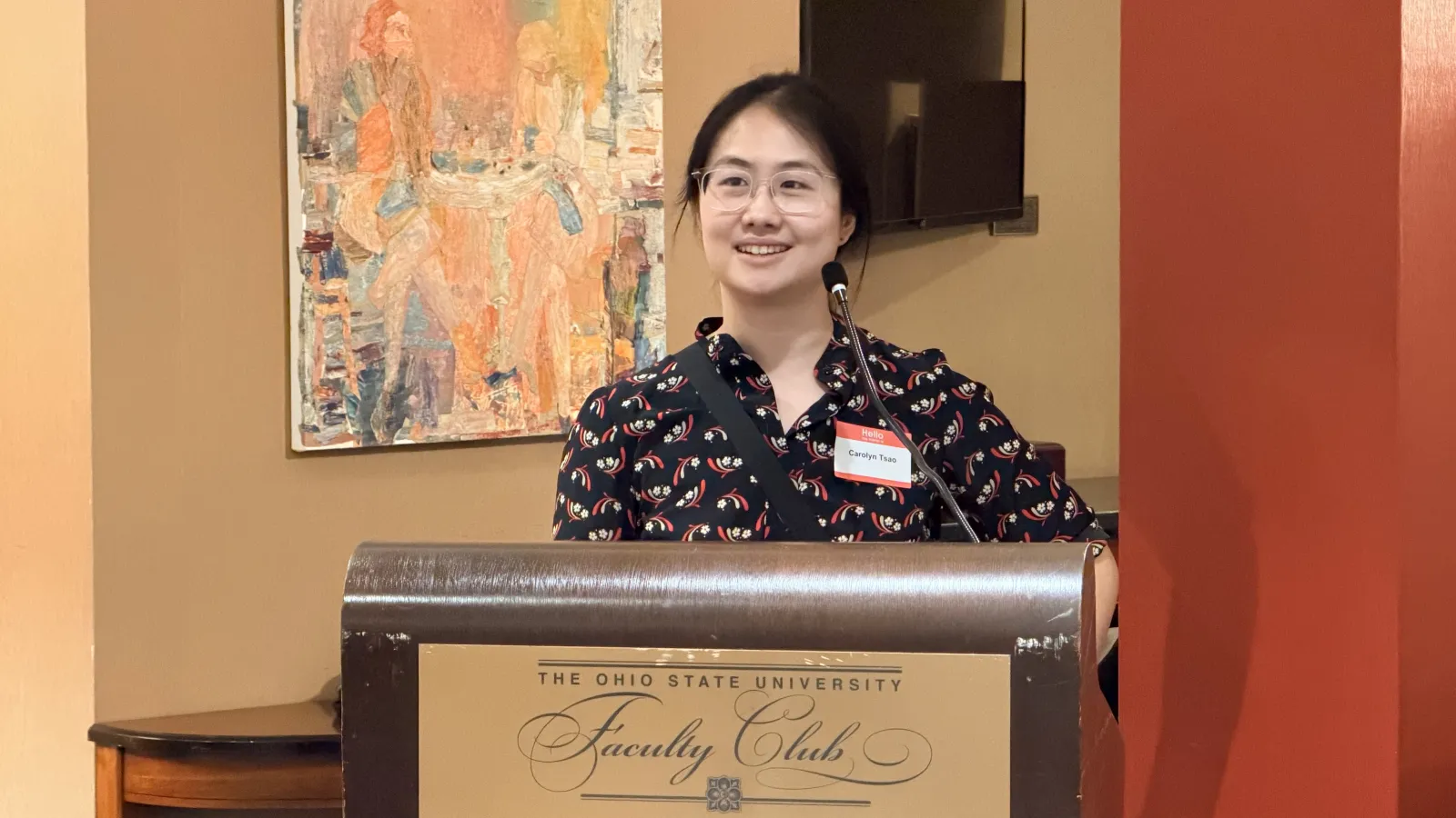 Assistant Professor Carolyn Tsao, smiling at the podium 
