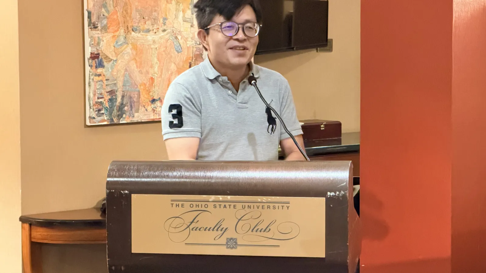 Department Chair, Huanxing Yang, smiling at the podium